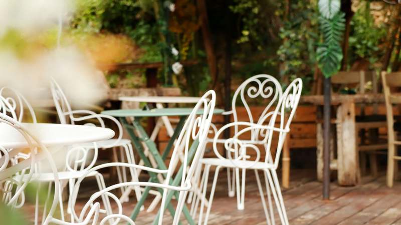 Gray modular outdoor sofa and coffee table under a wooden pergola with climbing vines and recessed lighting